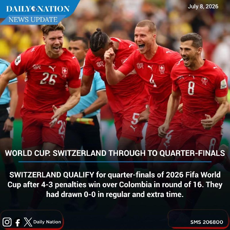 Four soccer players in red jerseys with white numbers celebrate enthusiastically while running together on a field.