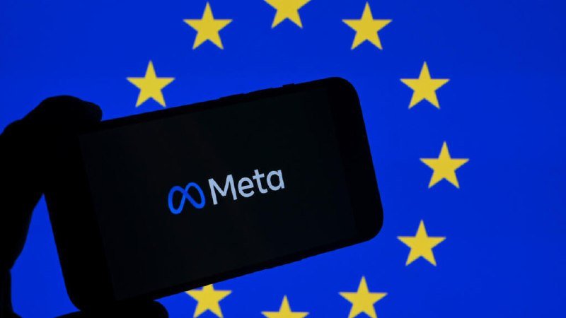 A hand holds a smartphone displaying the Meta logo against the blue and yellow stars of the European Union flag.