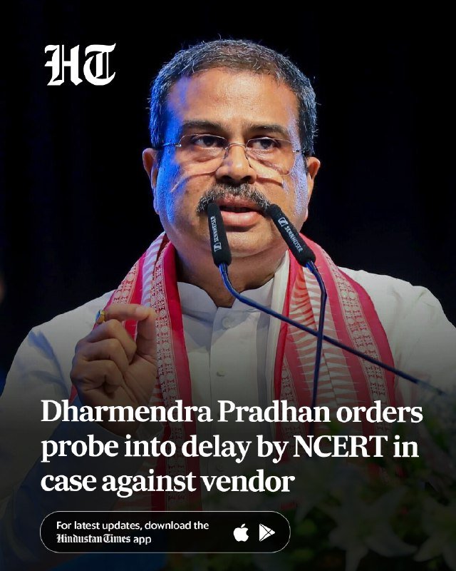 A man wearing glasses and a red-and-white scarf speaks at a podium with two microphones, with overlaid text reading "Dharmendra Pradhan orders probe into delay by NCERT in case against vendor."