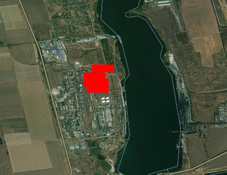 Satellite image showing an industrial complex beside a dark river, with several red rectangles overlaid marking specific facility locations.