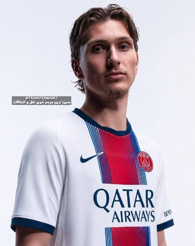 A young man with short brown hair poses wearing a white Paris Saint-Germain jersey featuring the "QATAR AIRWAYS" sponsor logo against a plain light background.