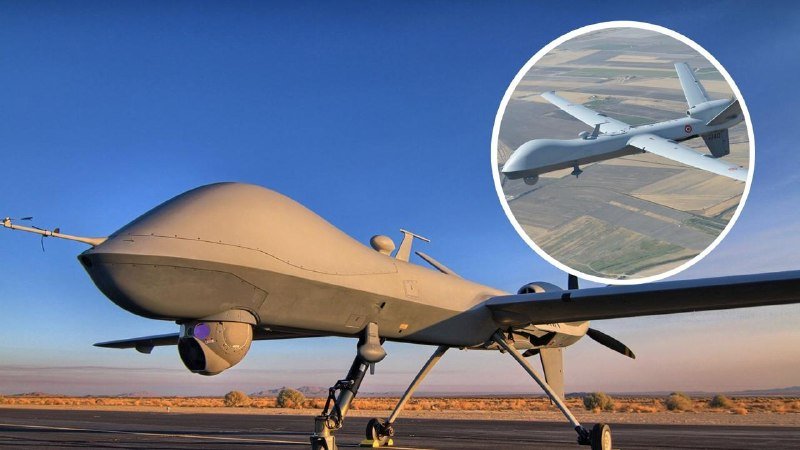 A large gray military drone sits on a runway under a clear blue sky, with an inset image showing a similar unmanned aircraft in flight over farmland.