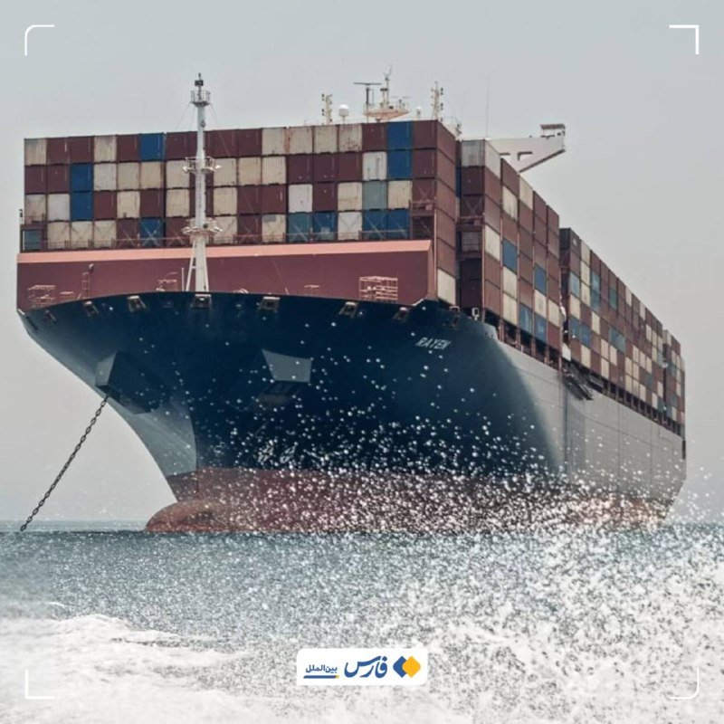 A large blue container ship stacked with multicolored shipping containers sails through the ocean.