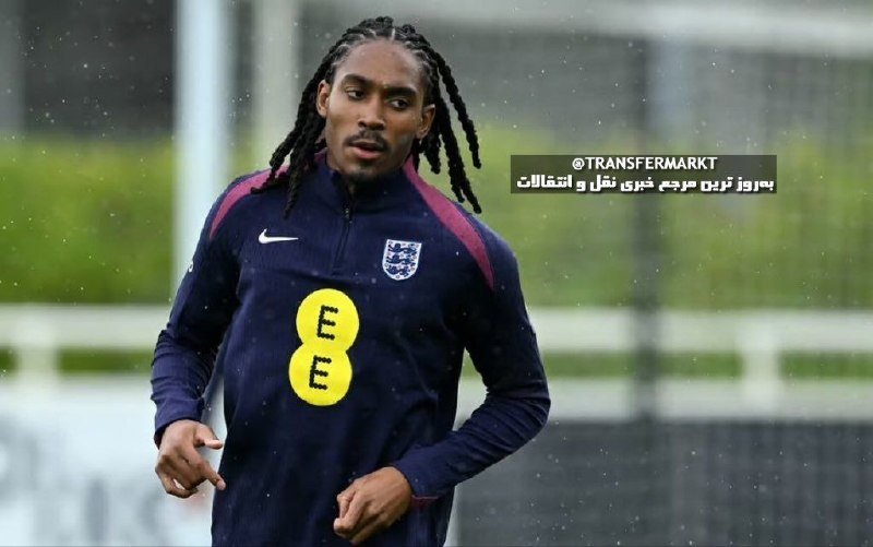 A footballer with dreadlocks trains in a navy England training top bearing the "EE" sponsor logo on an outdoor pitch.