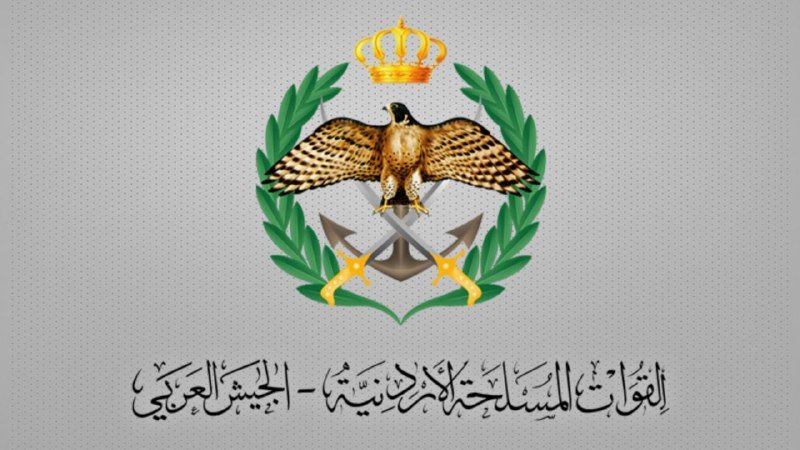 A graphic illustration displays a central emblem featuring a crowned falcon with outstretched wings above crossed swords, encircled by a green laurel wreath, with Arabic text below on a gray dotted background.