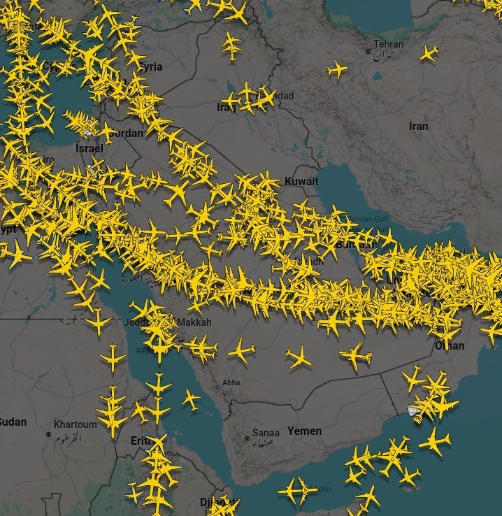 A flight-tracking map displays numerous yellow airplane icons densely clustered over the Middle East, including labeled regions such as Iran, Iraq, Saudi Arabia, Egypt, and the Persian Gulf.