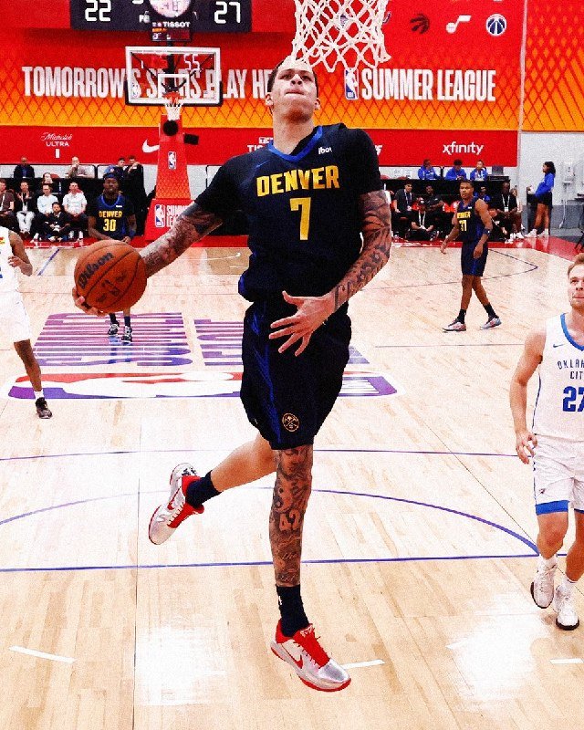 A tattooed basketball player wearing a Denver jersey numbered 7 leaps mid-air toward the hoop holding a ball on a summer league court.