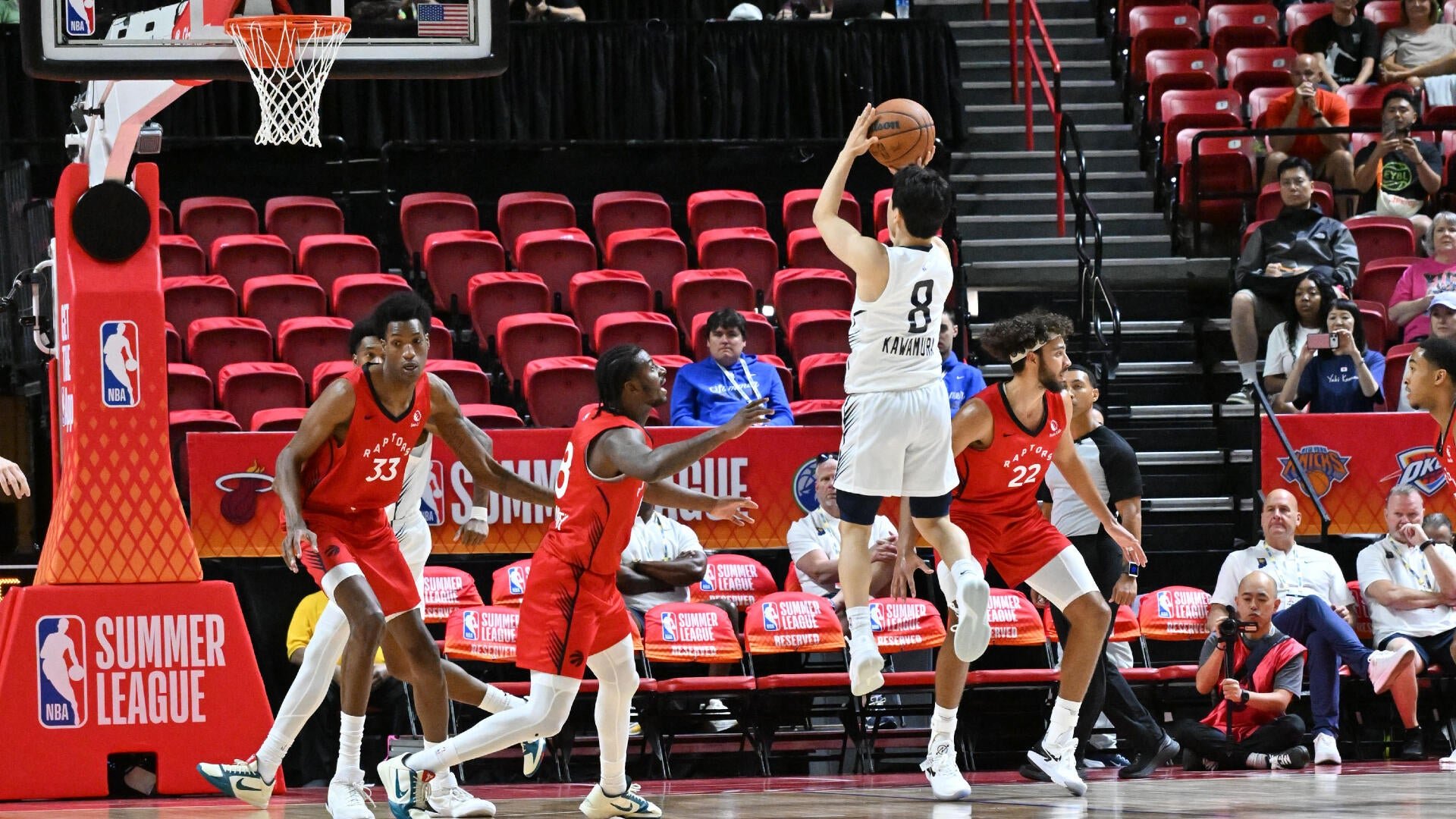 A basketball player wearing a white jersey numbered 8 with "KAWAMURA" shoots the ball during an NBA Summer League game against players in red Raptors jerseys.