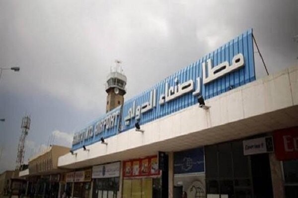 The exterior of an airport terminal with blue signage displays "BURAYDAH AIRPORT" in English and Arabic lettering under an overcast sky, alongside a watchtower and communications mast.