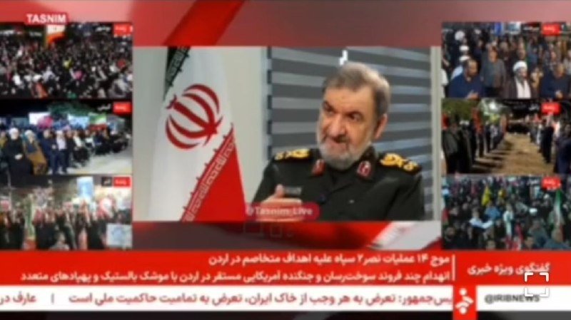 A bearded man in a military uniform speaks during a Persian-language news broadcast on the Tasnim and IRIB News networks, with an Iranian flag and crowd footage visible.