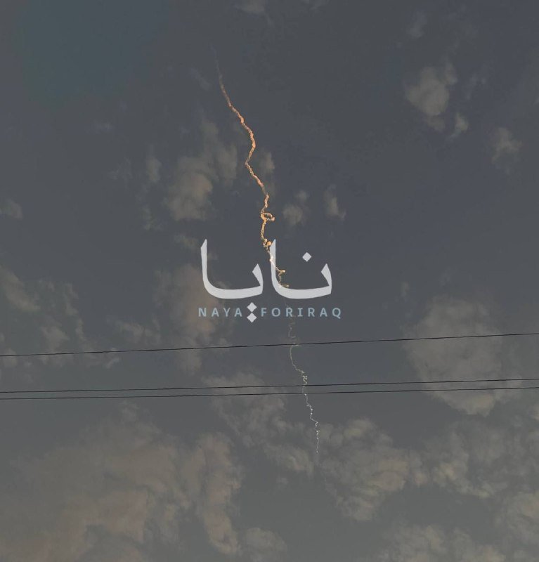 Graphic illustration showing a jagged lightning bolt striking through white Arabic and "NAYA FORIRAQ" text against a dark, cloudy sky background crossed by two power lines.