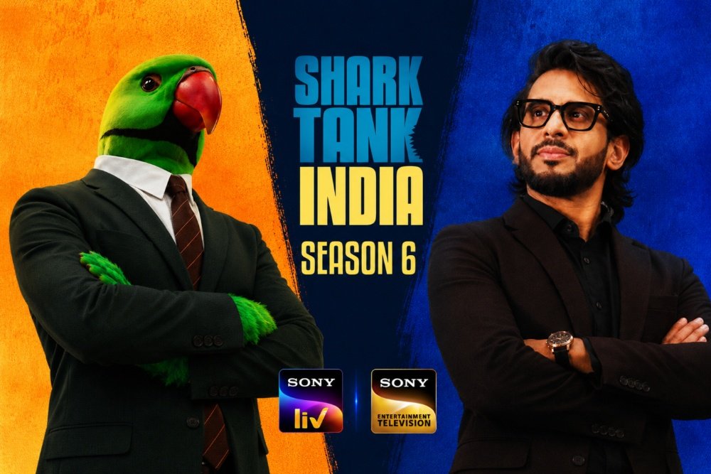 Promotional graphic for "Shark Tank India Season 6" featuring a green parrot in a suit beside a bearded man with glasses, with Sony LIV logos below.
