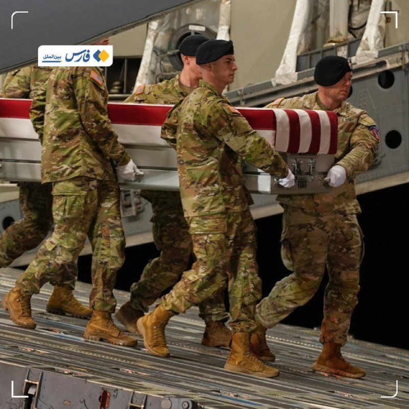 Military personnel in camouflage uniforms and white gloves carry a flag-draped casket from an aircraft ramp.