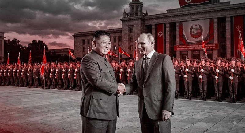 Two men in suits shake hands in front of a grand building flanked by rows of uniformed soldiers holding flags under a dark, cloudy sky.