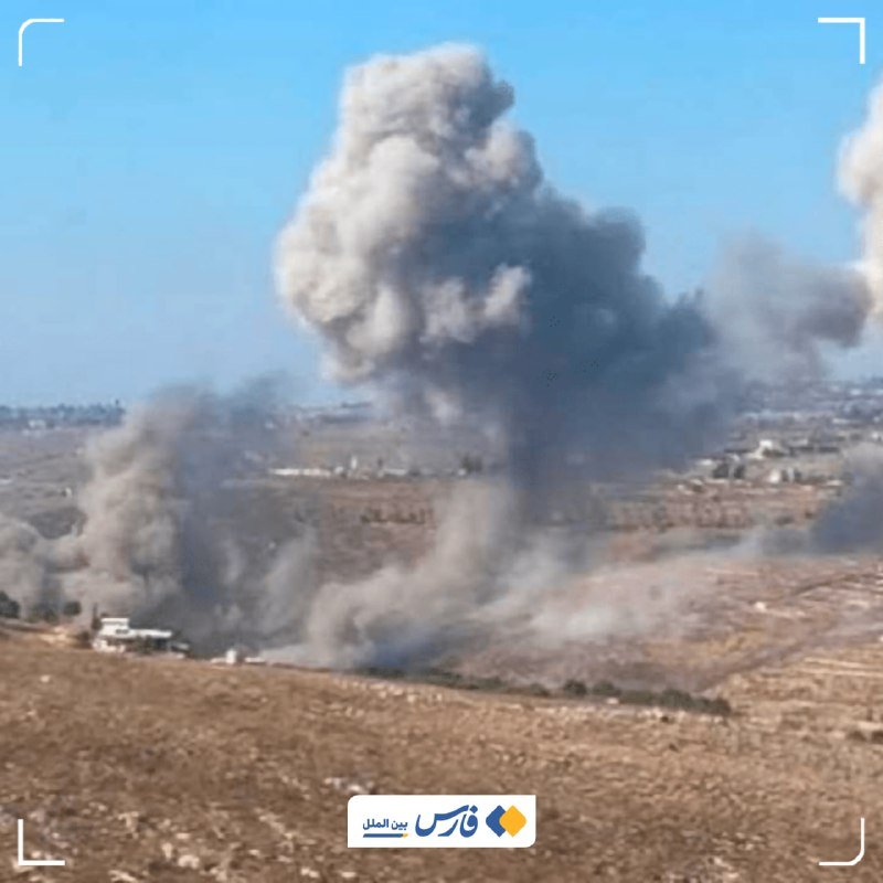A large plume of gray smoke rises from an open field, with smaller buildings visible in the distance under a blue sky.