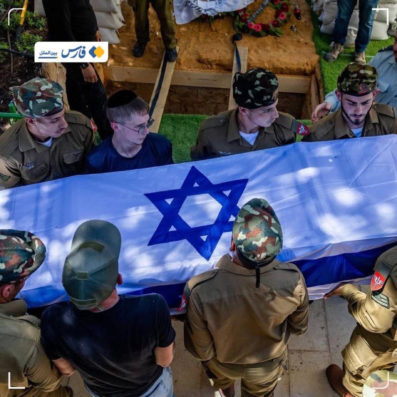 Uniformed soldiers in camouflage and civilians carry an Israeli flag-draped coffin at a funeral ceremony with floral arrangements nearby.