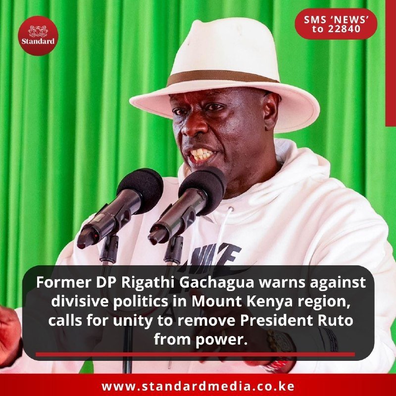 A man in a white hat and Nike hoodie speaks into two microphones against a green curtain backdrop, with a news caption overlay from Standard Media.