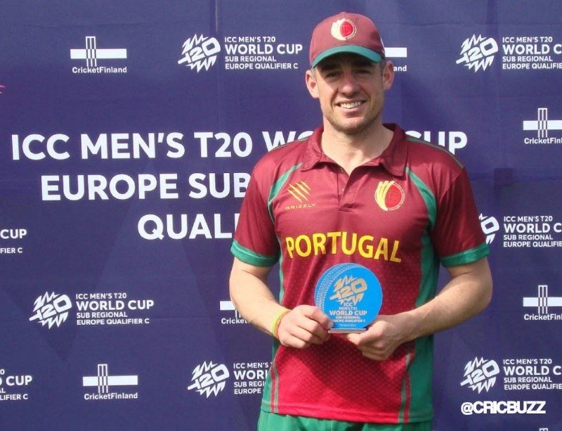 A smiling man in a Portugal cricket jersey and cap holds a "Player of the Match" award in front of an ICC Men's T20 World Cup Europe Sub Regional Qualifier C backdrop.