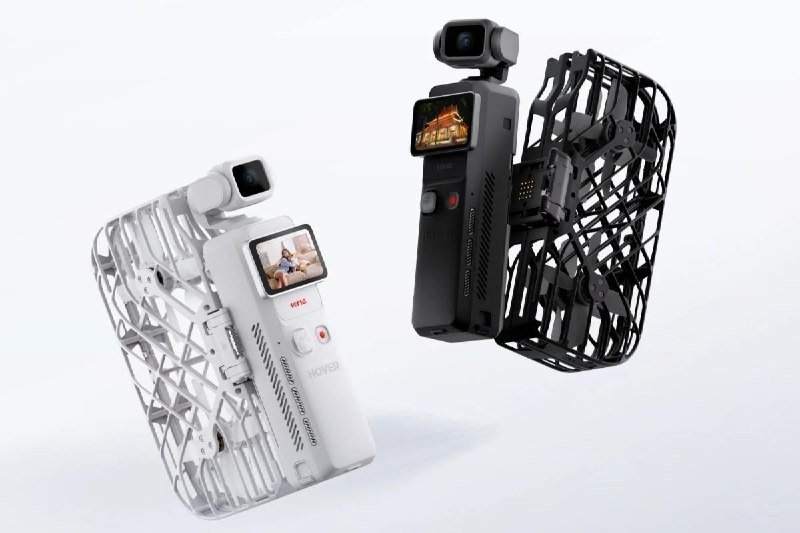 Two handheld drones, one white and one black, each featuring a top-mounted camera, small display screen, and enclosed propeller guards, displayed against a white background.
