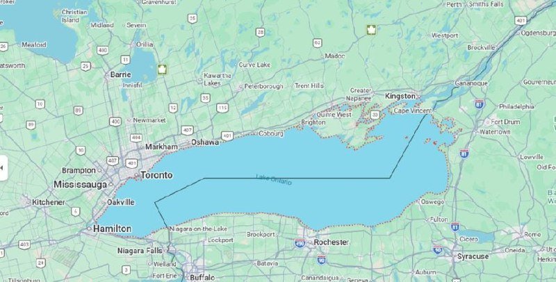 A digital map displays a large blue-shaded outlined area spanning Lake Ontario between Toronto and Kingston, with numerous small orange dots scattered along its southern shoreline.