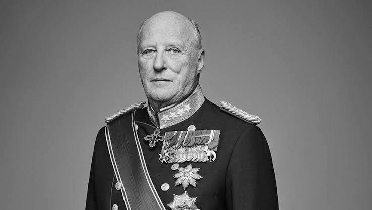 Black-and-white portrait of a bald, older man in a decorated military uniform with medals, sashes, and star insignia against a gray background.