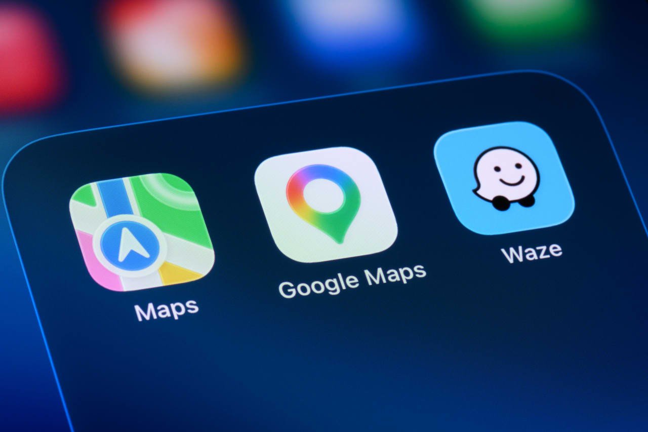 Close-up of a smartphone screen displaying the Apple Maps, Google Maps, and Waze app icons.