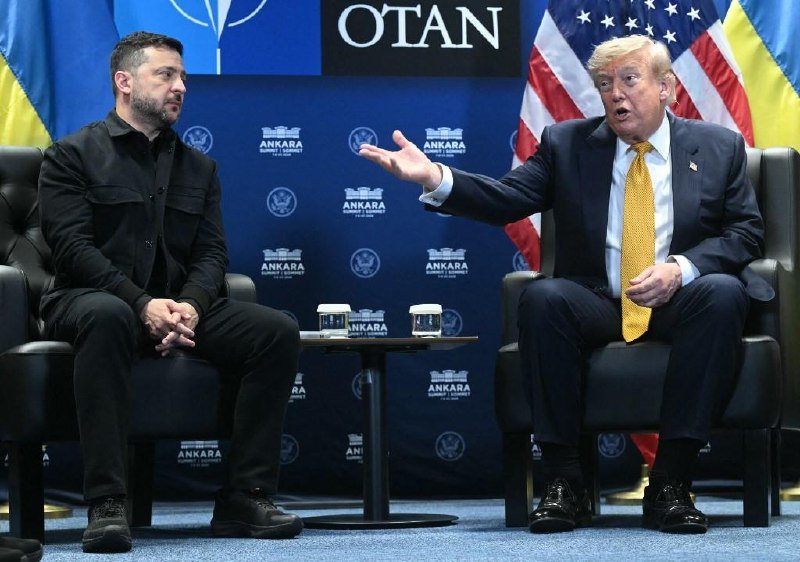Two men sit in black armchairs before a blue backdrop reading "ANKARA Summit & Summit" and "OTAN," with American and Ukrainian flags behind them; the man on the right gestures while speaking.