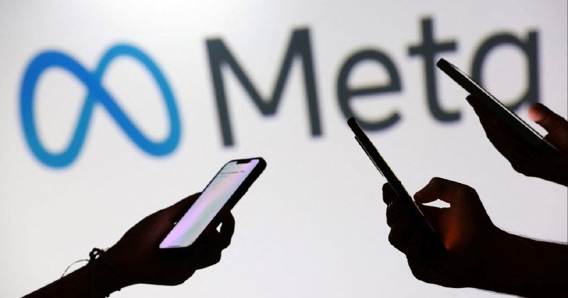 Silhouetted hands hold smartphones in front of an illuminated screen displaying the Meta logo and wordmark.